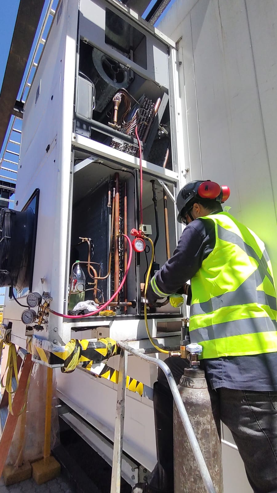Técnico em campo realizando inspeção em sistema de refrigeração — experiência profissional acumulada em HVAC.